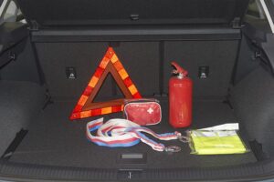 Emergency car kit with a hazard triangle, fire extinguisher, first aid kit, and tow straps in Springfield, IL.