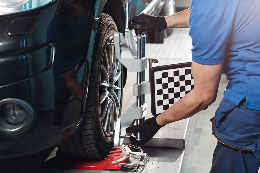 A professional mechanic performs a wheel alignment service on a car in Springfield, IL.