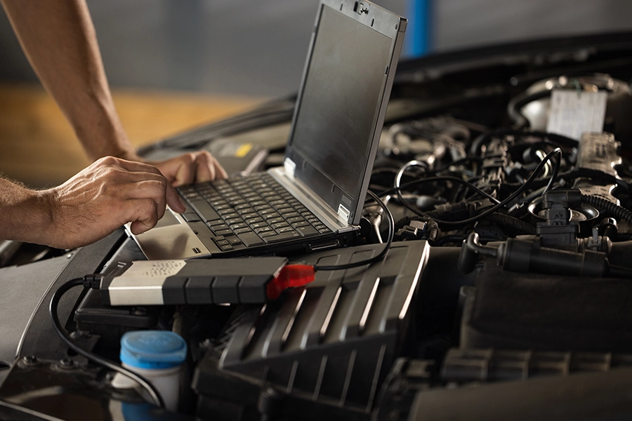 Mechanic using a computer to perform a computer diagnostic service on a vehicle in Springfield, IL.