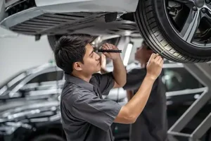 Jack Stoldt Auto Service—A professional mechanic examines a car’s tires in a shop in Springfield, IL.