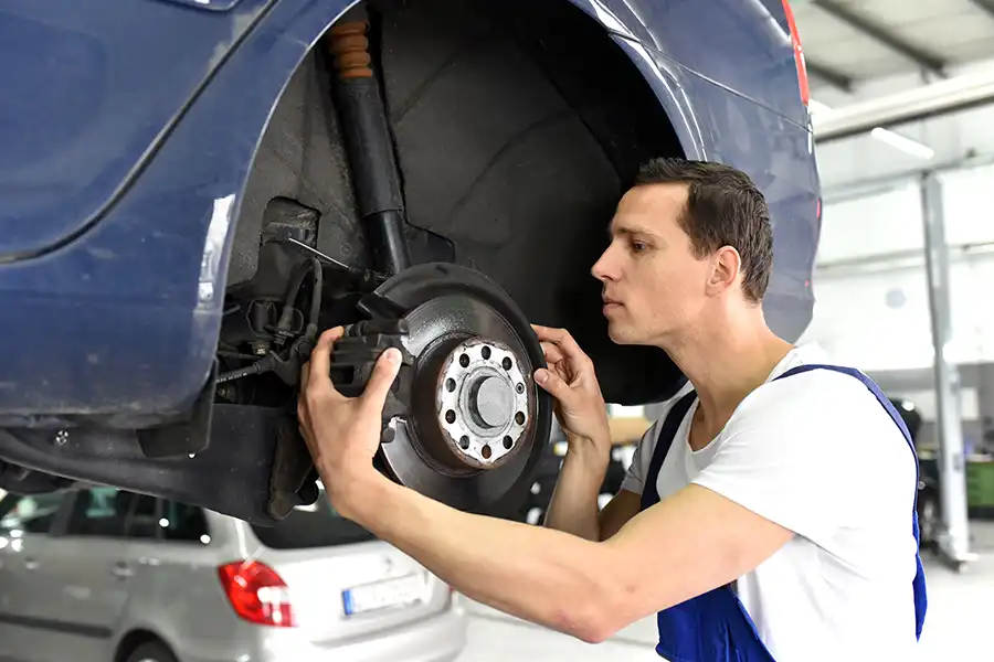 Jack Stoldt Auto Service Center—A car mechanic repairs the brakes of a vehicle on the lifting platform in a workshop in Springfield, IL.