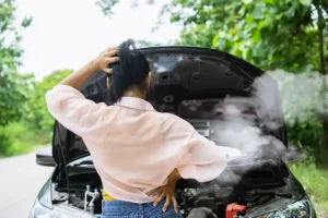 Jack Stoldt Auto Service Center—A young woman standing in front of an overheated car while pulled over on the side of the road in Springfield, IL.
