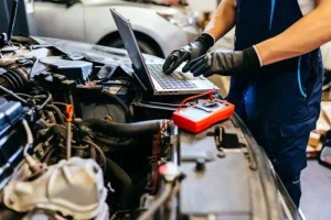 Jack Stoldt Auto Service—An auto mechanic using a computer and seeking technology trends to diagnose problems with a vehicle in a garage in Springfield, IL.
