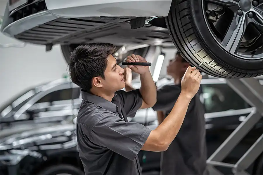 Jack Stoldt Auto Service—A professional mechanic examines a car’s tires in a shop in Springfield, IL.
